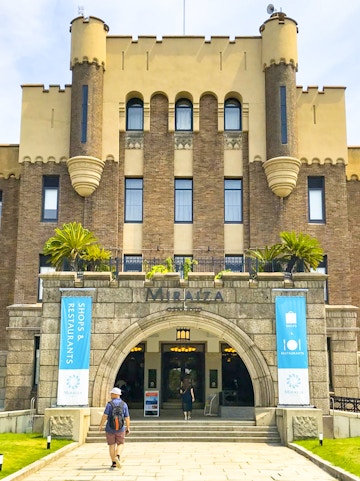 Entrance of Mirai Museum, featuring banners for shops and restaurants, related to the Illusion Museum and Magic Show.