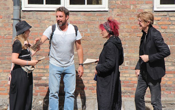 Participants discussing clues during a murder mystery at Christiansborg Palace.