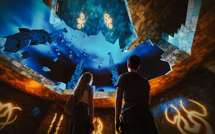Visitors exploring immersive underwater scene at The Lost World Aquarium.