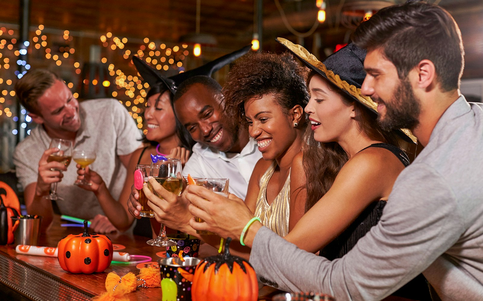 Group celebrating Halloween at Energylandia with drinks and festive decorations.