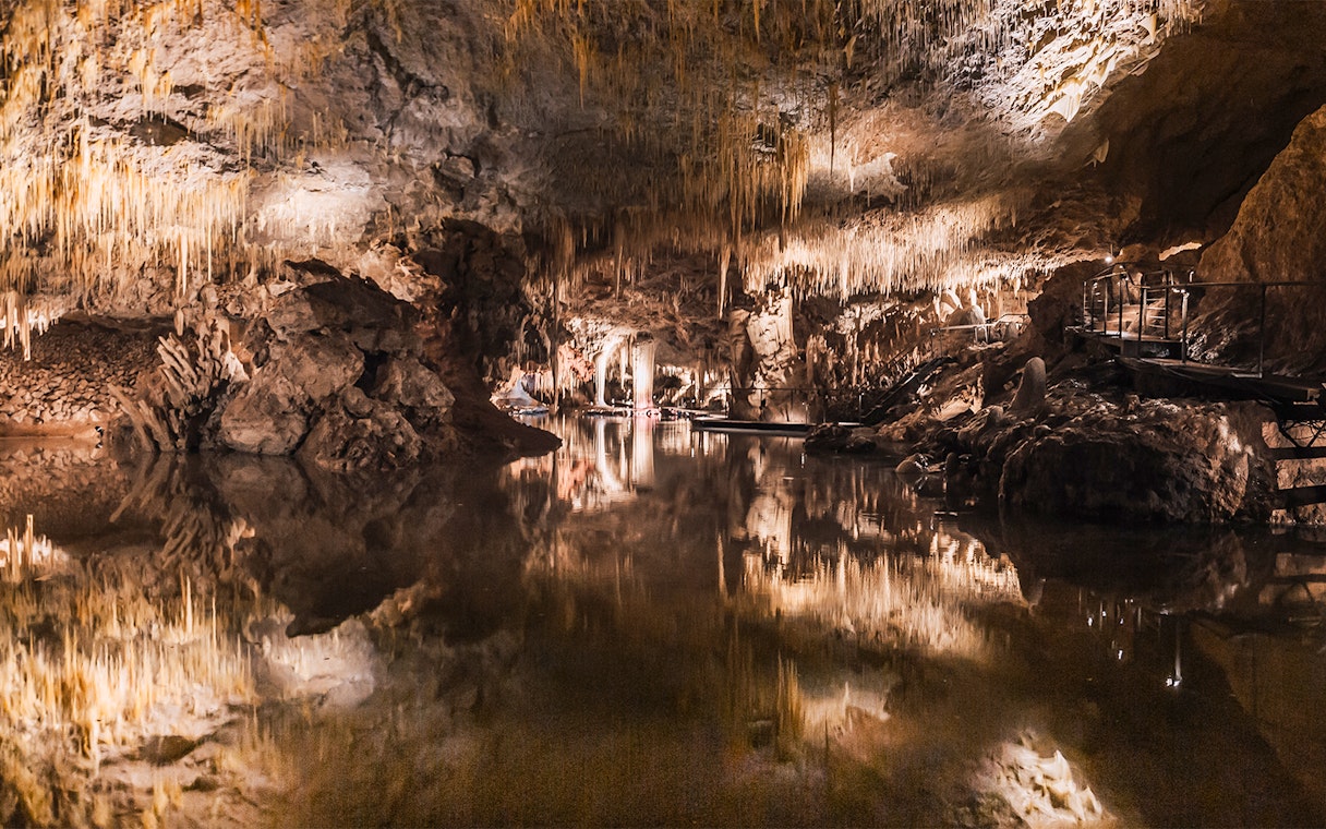 Stalactites reflected in still water inside Lake Cave, Margaret River.