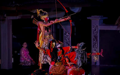 Traditional Javanese dancers perform the Ramayana epic with costumes and bows on stage.