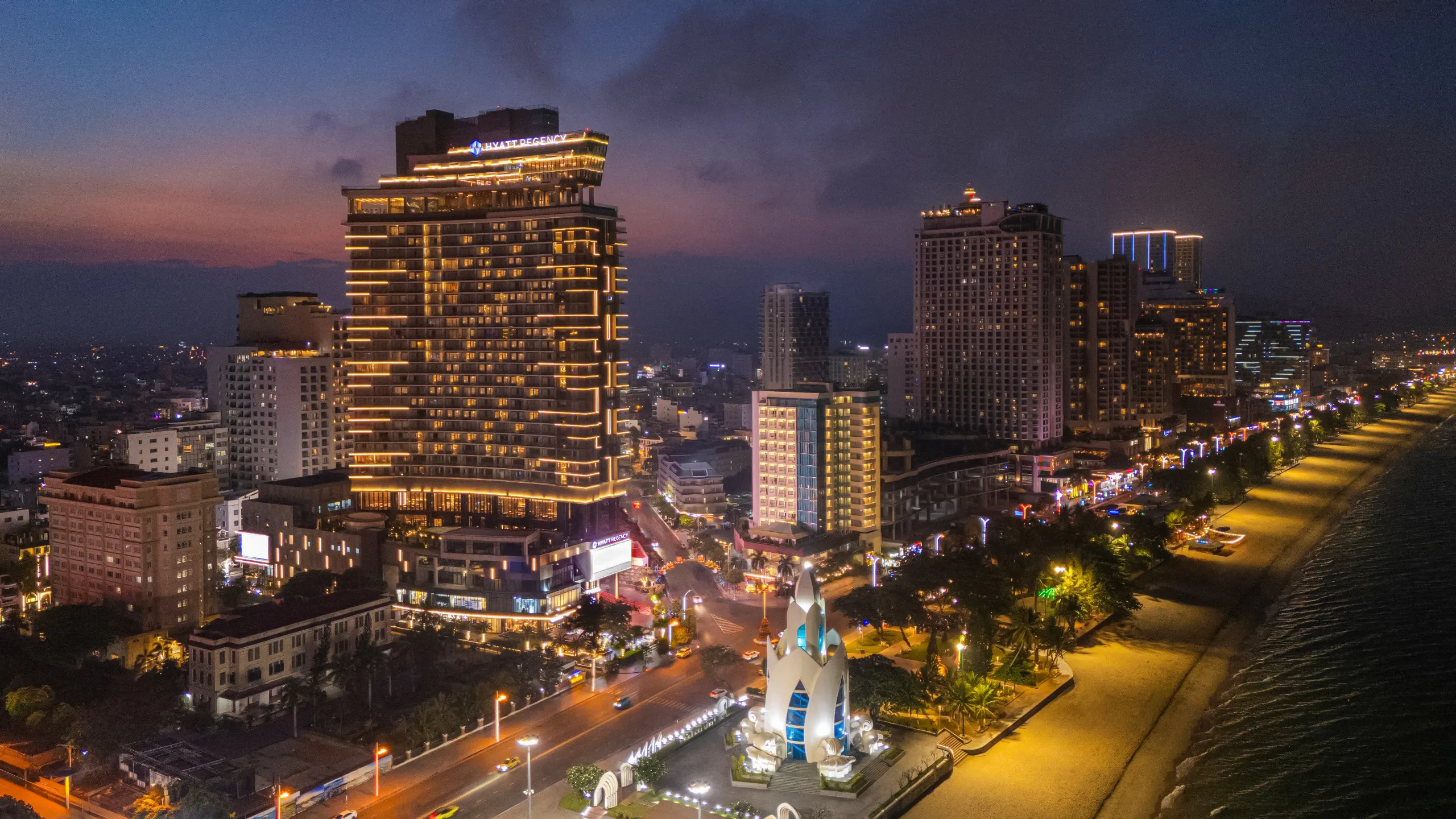 Hyatt Regency Nha Trang illuminated at night, beachfront view, Nha Trang cityscape.