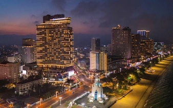 Hyatt Regency Nha Trang illuminated at night, beachfront view, Nha Trang cityscape.