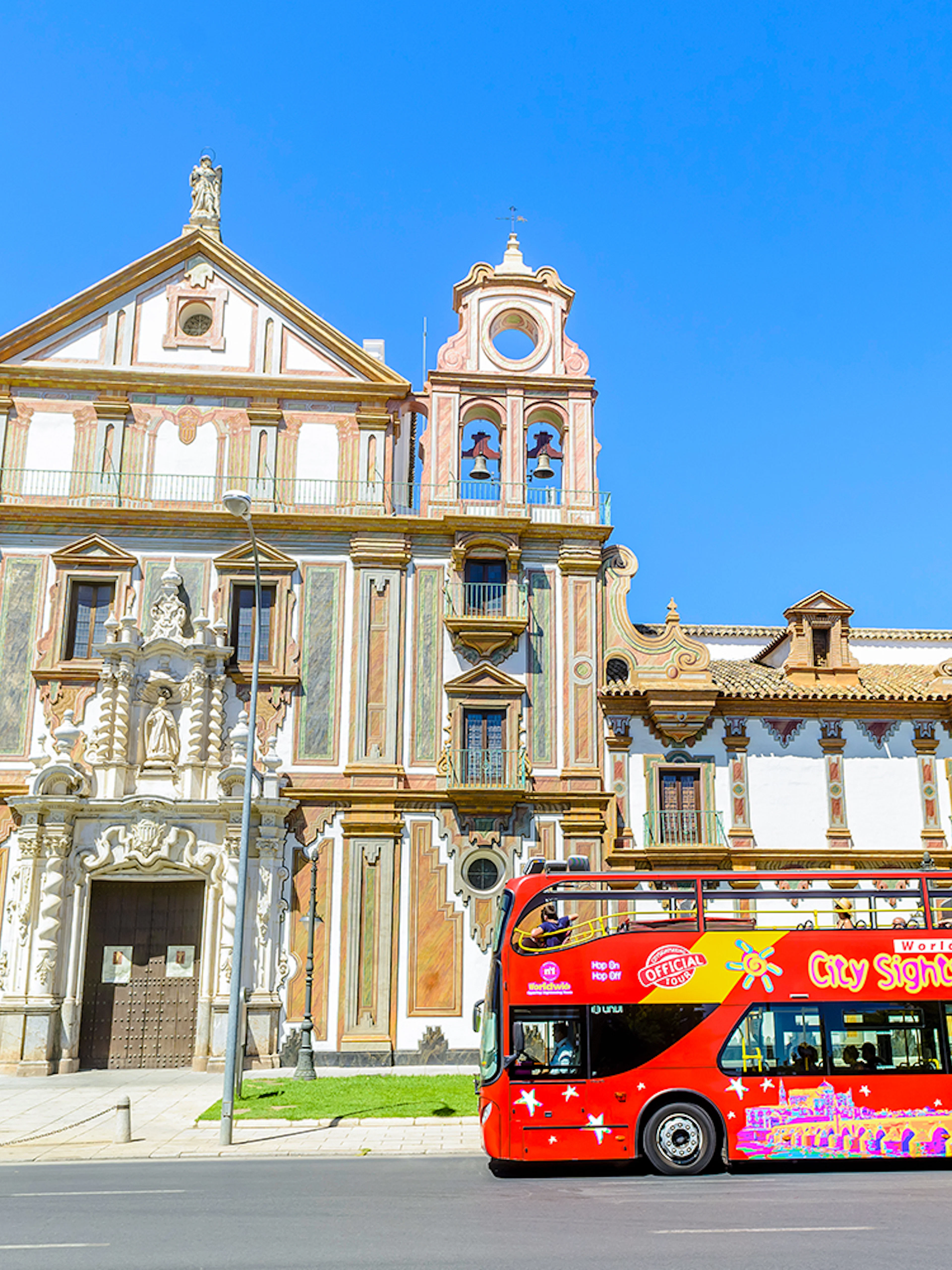 City sightseeing bus in front of historic building in Córdoba.