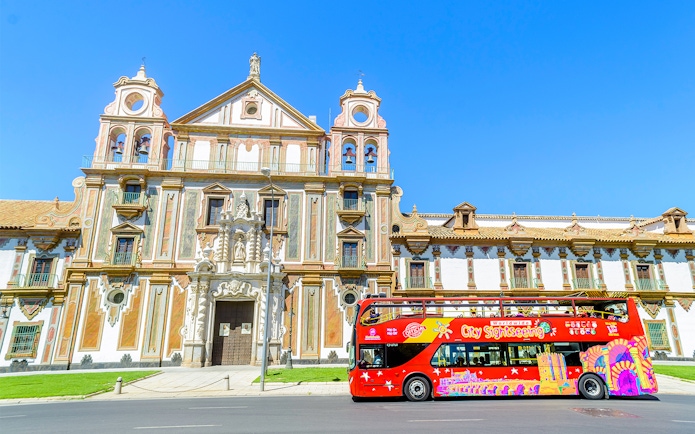 City sightseeing bus in front of historic building in Córdoba.