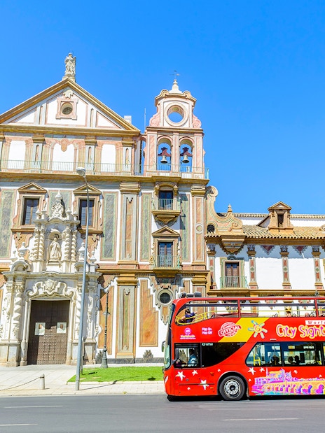 City sightseeing bus in front of historic building in Córdoba.