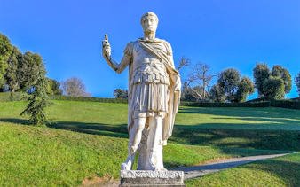 Statue of a Roman figure holding a scroll in Boboli Gardens, Florence.