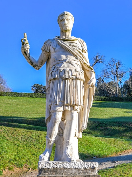 Statue of a Roman figure holding a scroll in Boboli Gardens, Florence.
