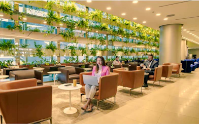 Al Maha Lounge seating area with guests at Doha Hamad International Airport.