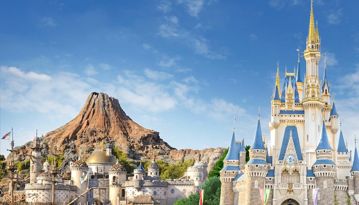 Visitors enjoying attractions at Tokyo DisneySea with iconic Mount Prometheus in the background.