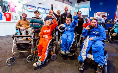 Group of people in wheelchairs celebrating at iFLY Indoor Skydiving Experience.