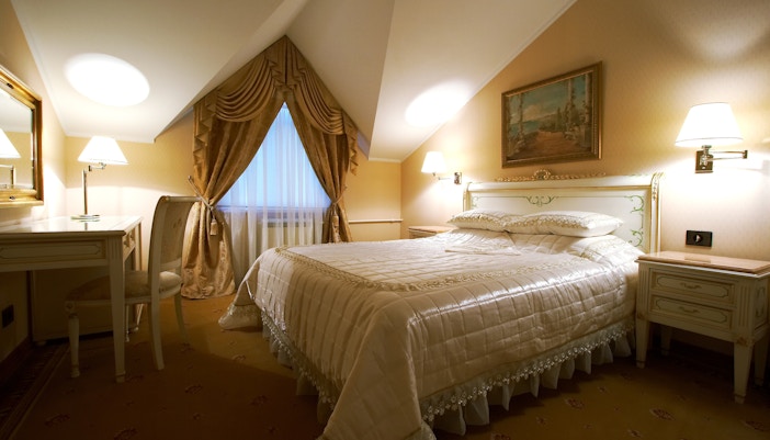 Luxury hotel room with king-sized bed, modern decor, and large windows