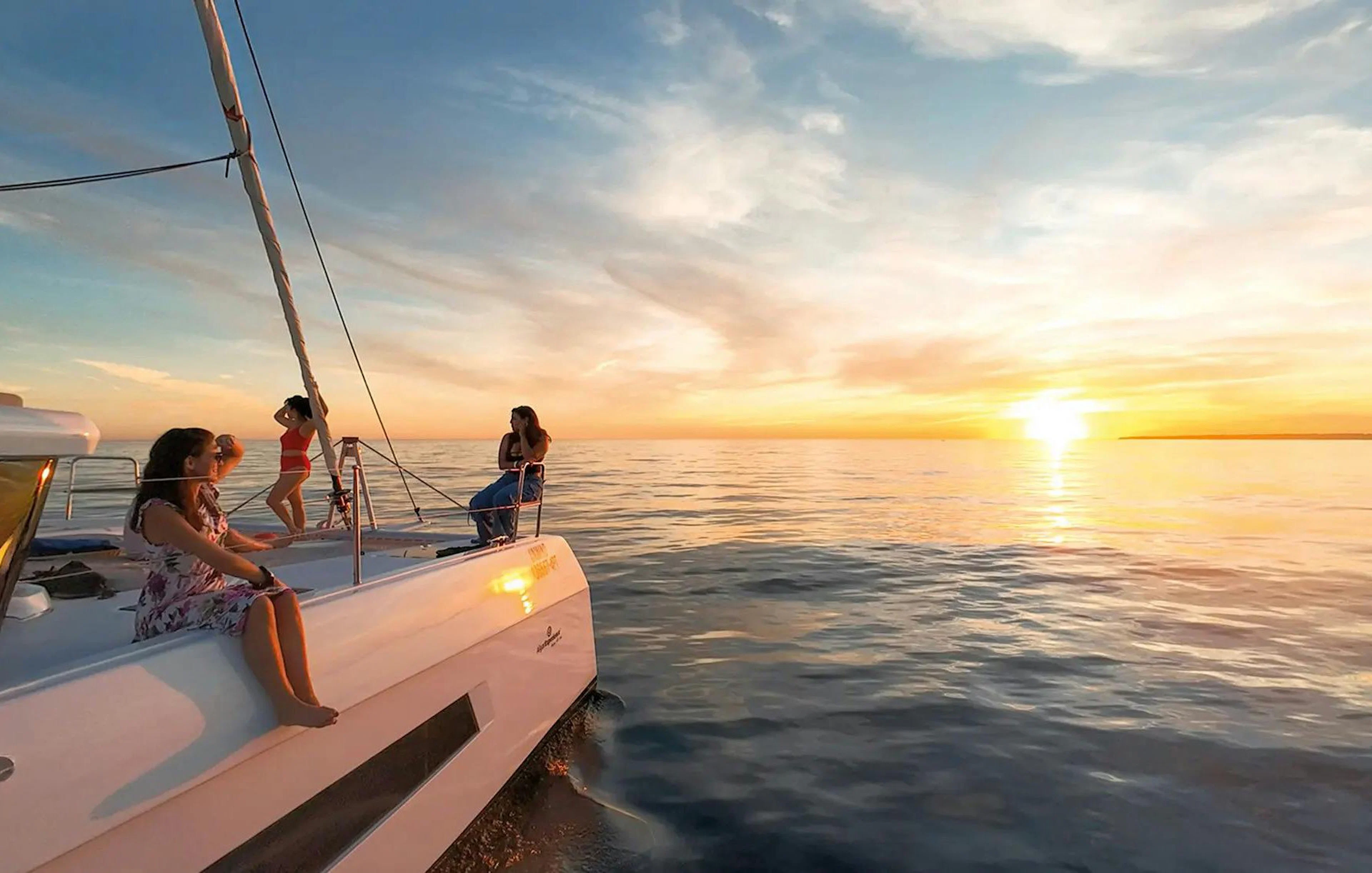 Sailing tour at sunset in Algarve from Vilamoura with people on deck.