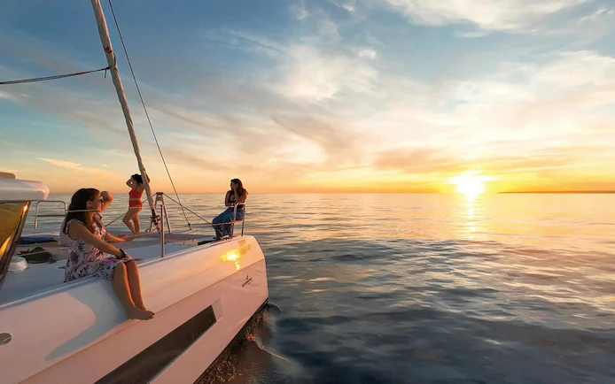 Sailing tour at sunset in Algarve from Vilamoura with people on deck.