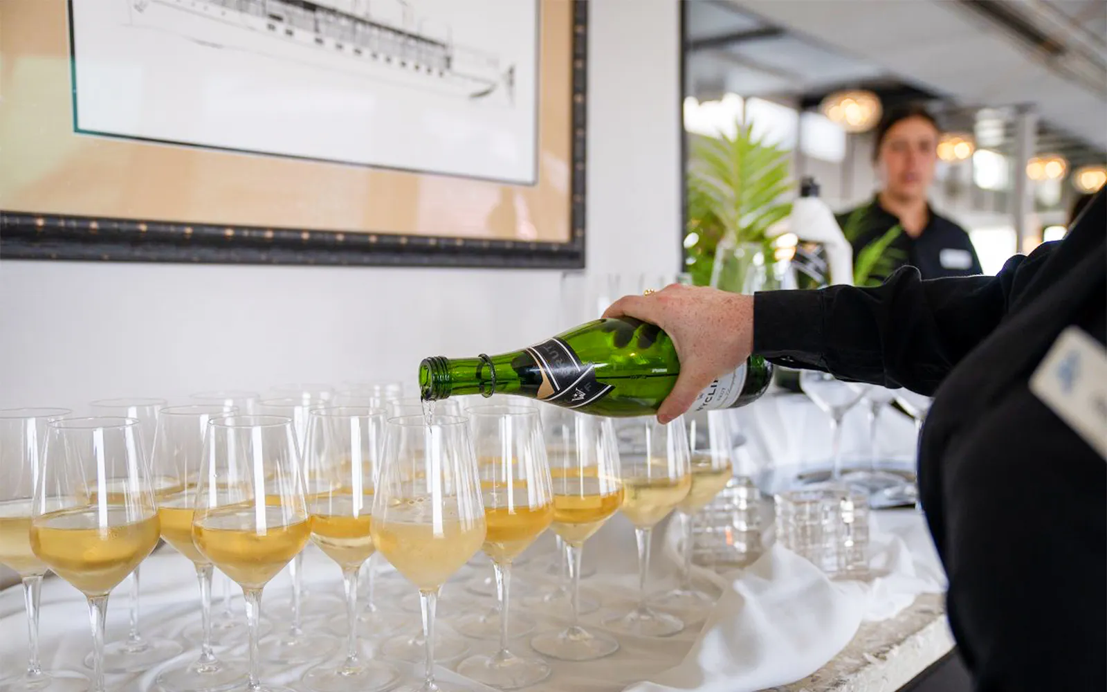 Waitress pouring champagne on San Diego brunch cruise.