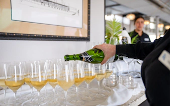 Waitress pouring champagne on San Diego brunch cruise.