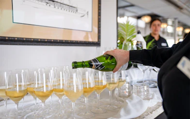 Waitress pouring champagne on San Diego brunch cruise.
