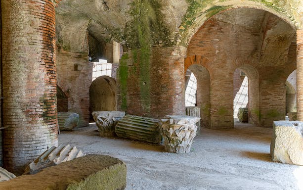 Flavian Amphitheater interior with ancient brick arches and stone columns in Pozzuoli.
