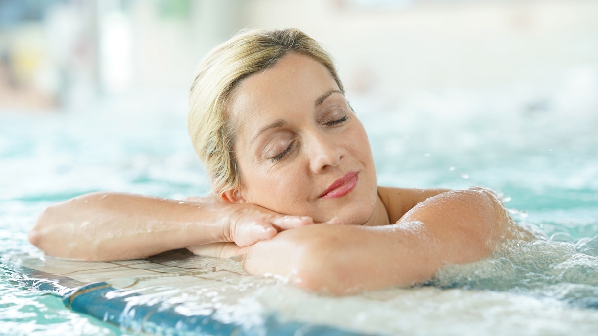 Woman relaxing in an indoor thermal bath.