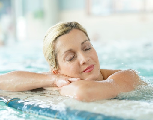 Woman relaxing in an indoor thermal bath.