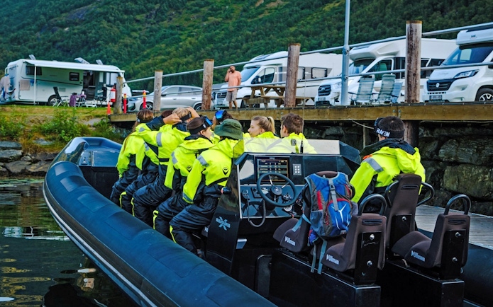 People in bright jackets seated on a RIB boat for a fjord safari in Geiranger.
