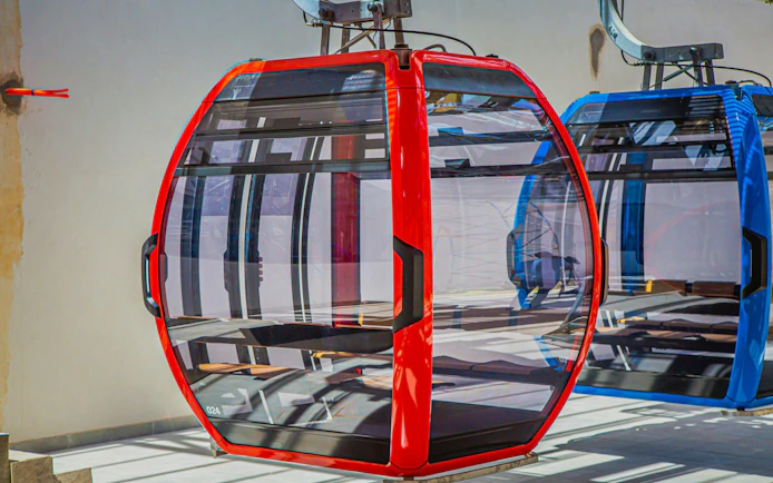 Red and blue cable cars at a station for night round-trip ticket experience.