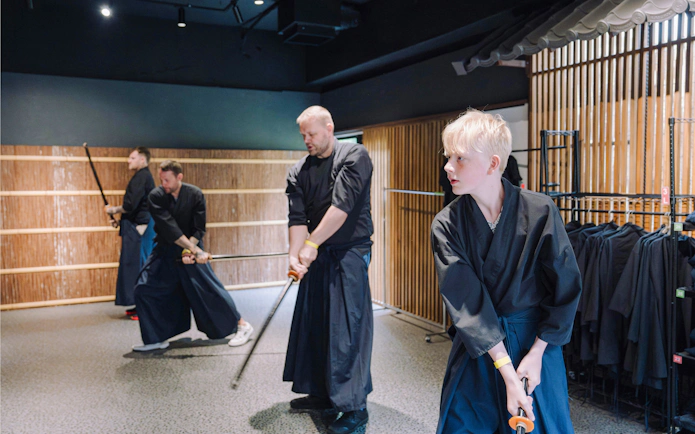 Young men practicing samurai sword techniques in Shinjuku dojo.