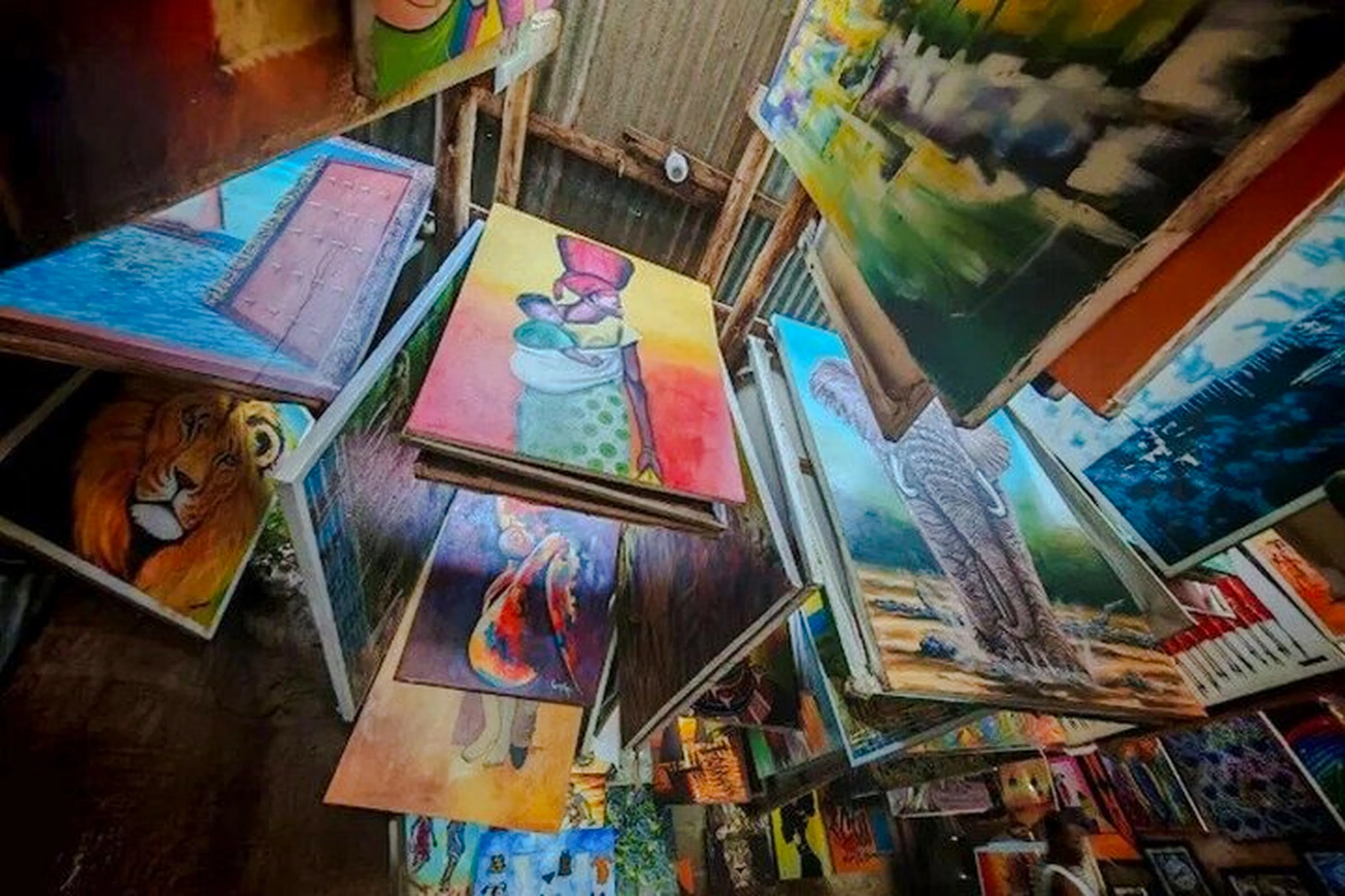 Colorful paintings displayed at a market in Dar es Salaam, featuring wildlife and local scenes.