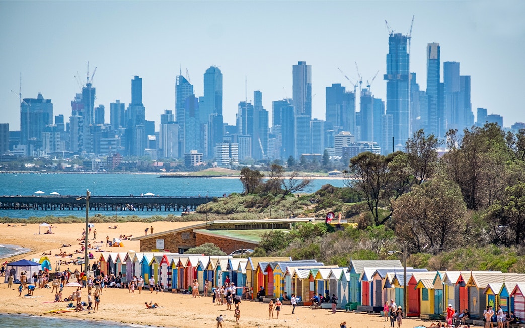 Brighton Beach colorful huts with Melbourne skyline in the background.