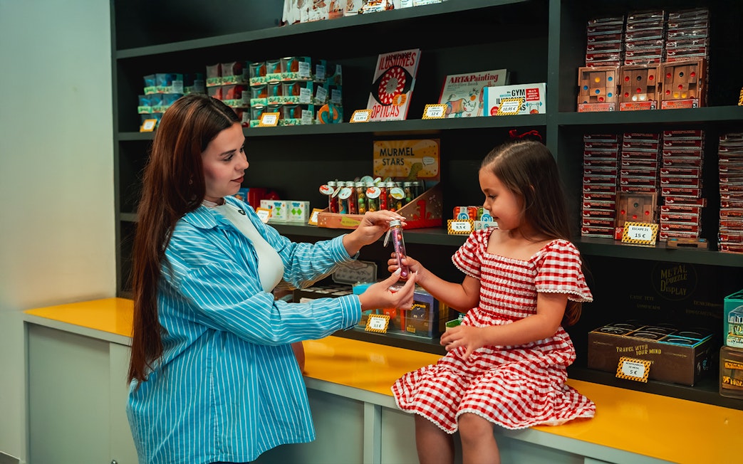 Child receiving a gift at the Museum of Illusions gift shop in Madrid.