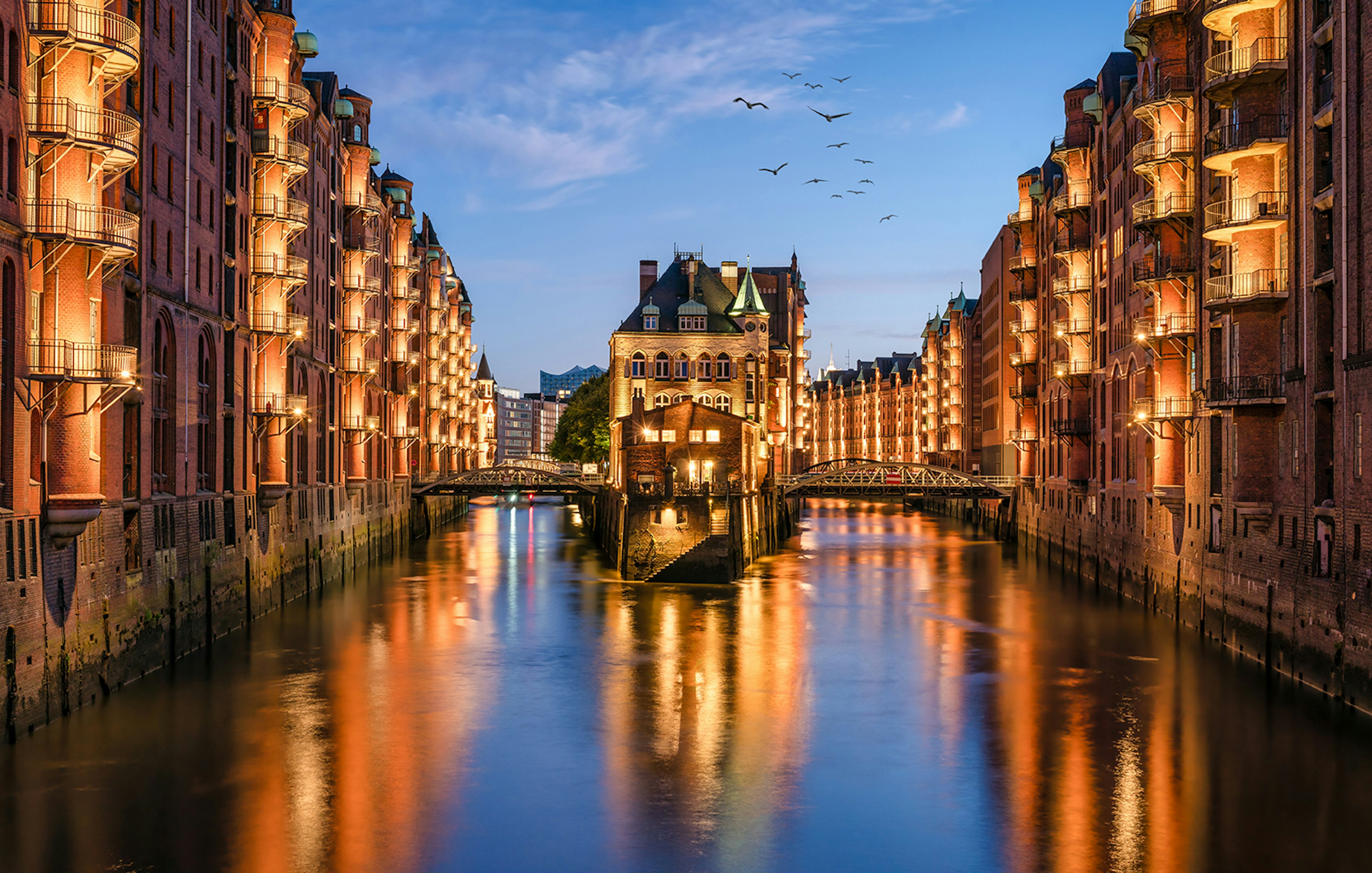 Evening view of illuminated Speicherstadt canal in Hamburg during a 1.5h Grand Evening Lights Cruise.