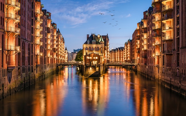 Evening view of illuminated Speicherstadt canal in Hamburg during a 1.5h Grand Evening Lights Cruise.