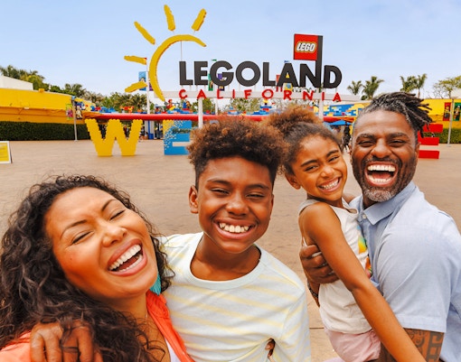 Family smiling at the entrance of LEGOLAND California.