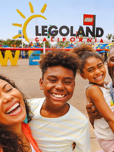Family smiling at the entrance of LEGOLAND California.