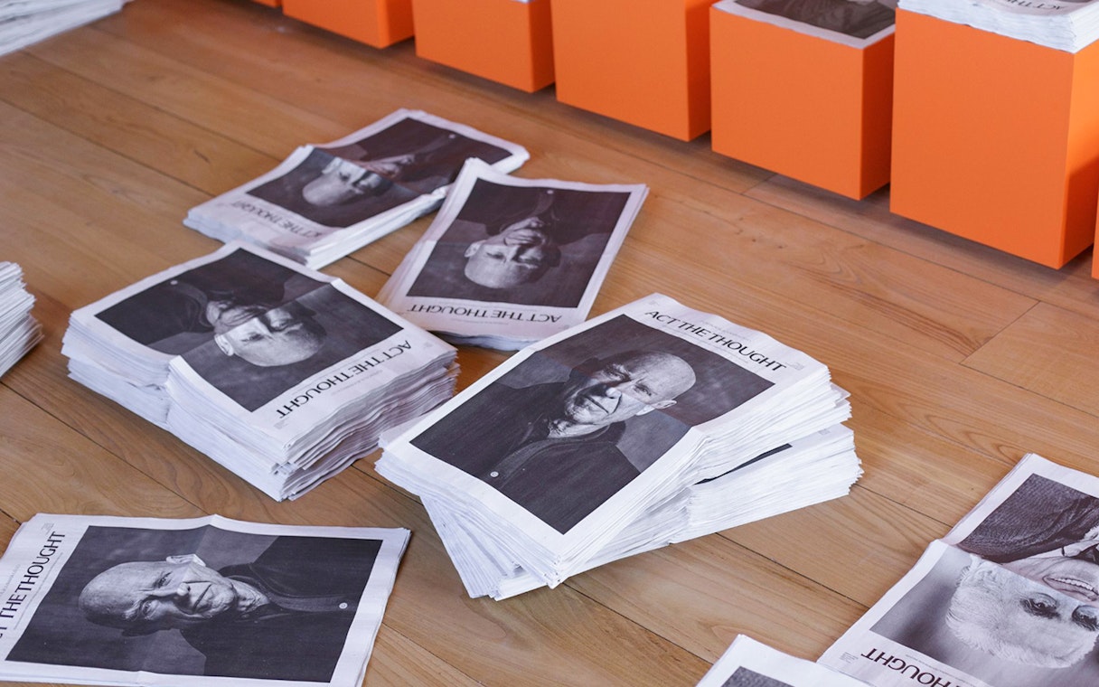 Stacks of newspapers with portraits on the floor at Lello Foundation Museum.