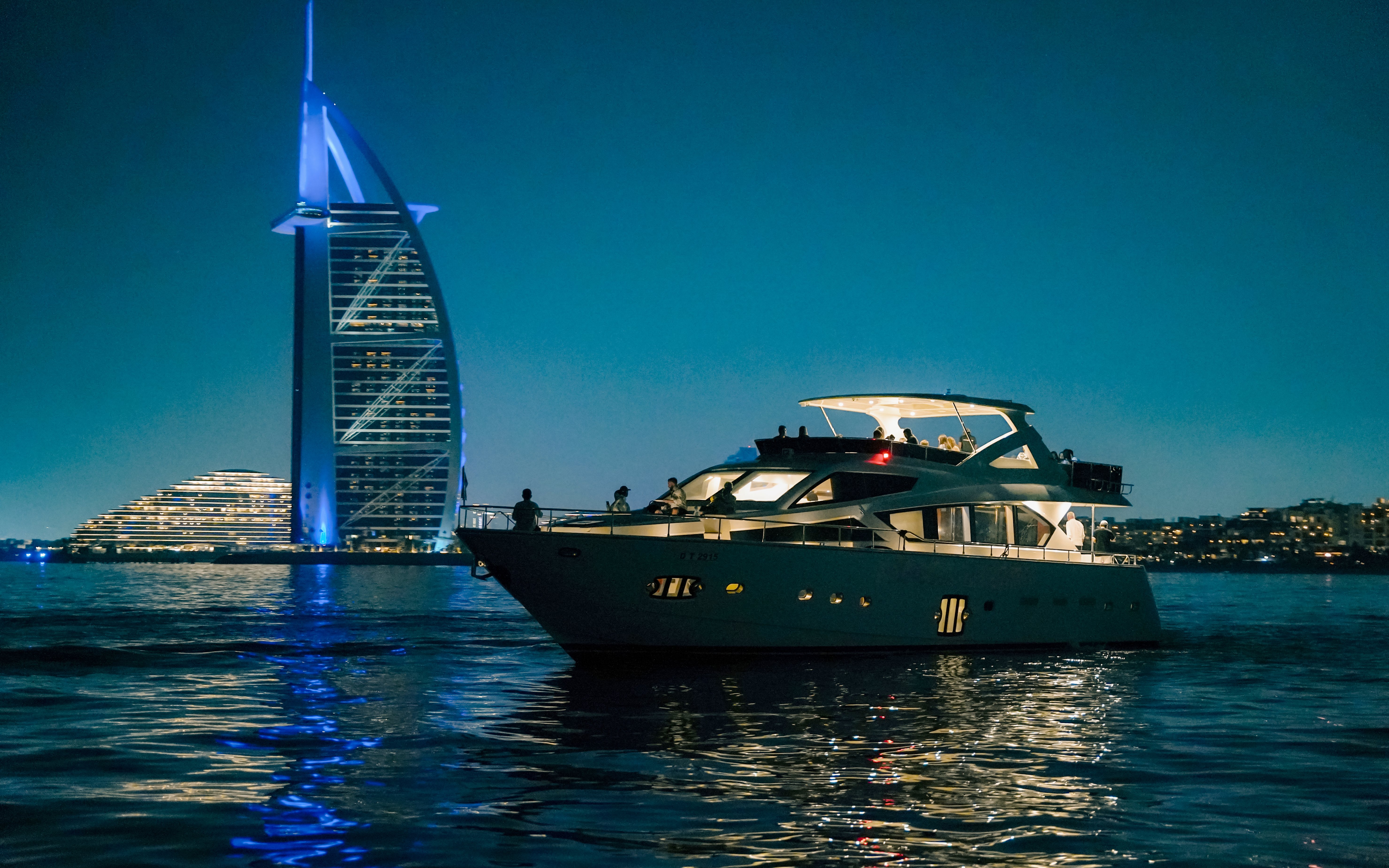 Luxury yacht cruising near Burj Al Arab at Dubai Harbour.