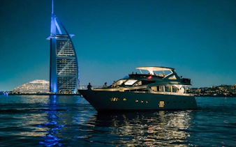Luxury yacht cruising near Burj Al Arab at Dubai Harbour.