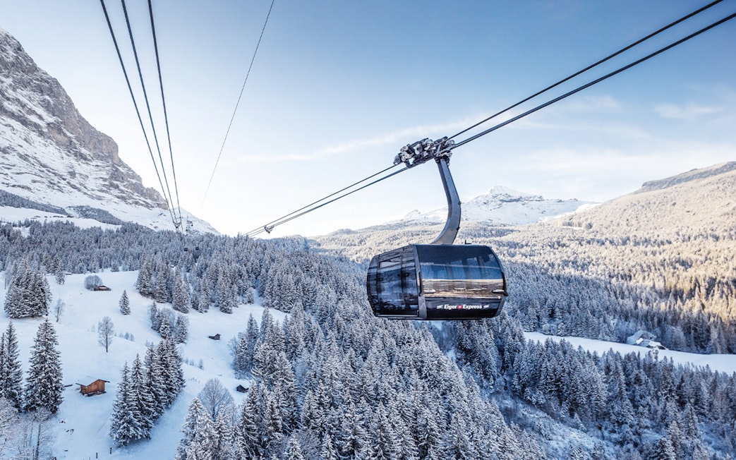 Cable car ascending snowy landscape towards Jungfraujoch from Interlaken East.