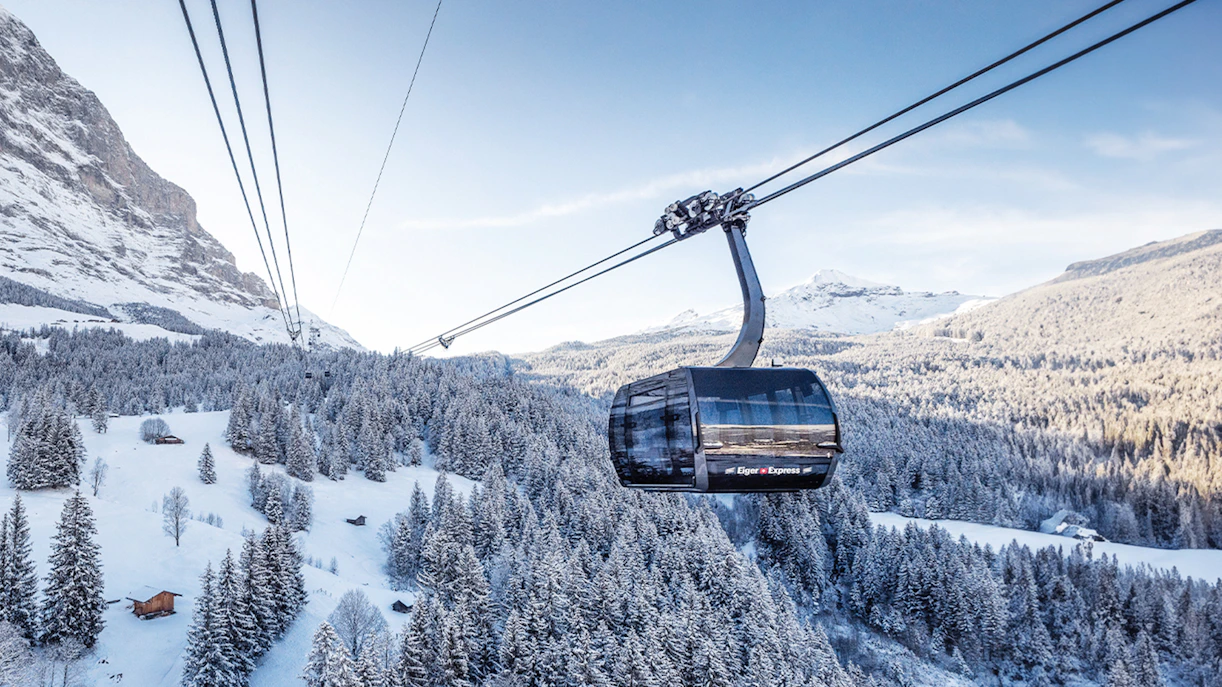 Cable car ascending snowy landscape towards Jungfraujoch from Interlaken East.