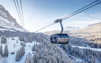 Cable car ascending snowy landscape towards Jungfraujoch from Interlaken East.