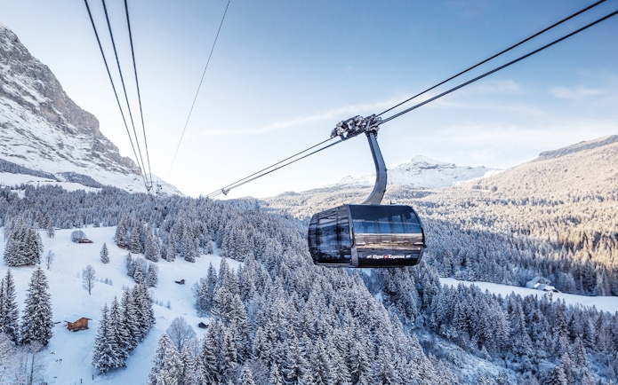 Cable car ascending snowy landscape towards Jungfraujoch from Interlaken East.