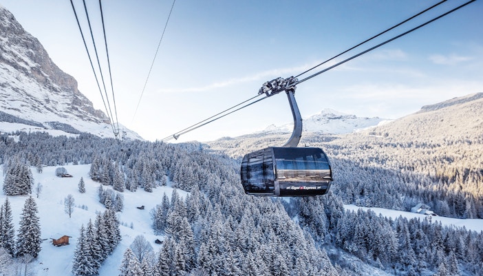 Cable car ascending snowy landscape towards Jungfraujoch from Interlaken East.