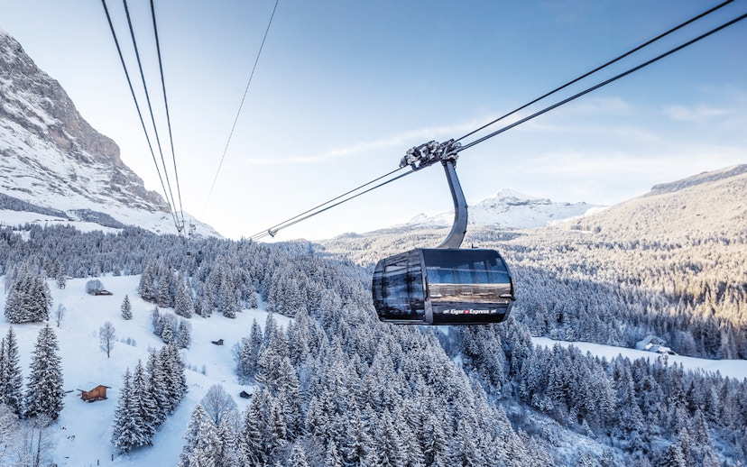 Cable car ascending snowy landscape towards Jungfraujoch from Interlaken East.