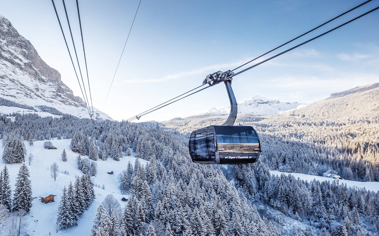Cable car ascending snowy landscape towards Jungfraujoch from Interlaken East.