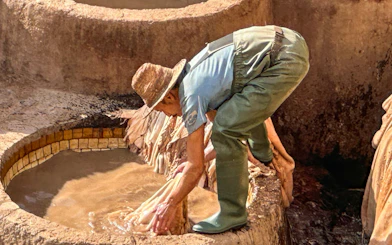 Worker processing leather in a tannery vat in Fes Medina.
