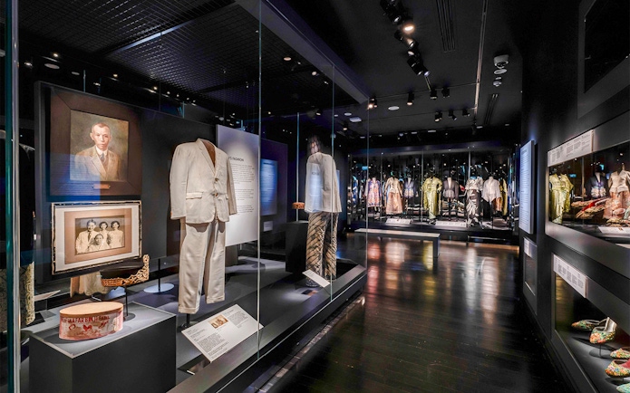 Peranakan Museum gallery showcasing traditional clothing and historical portraits.