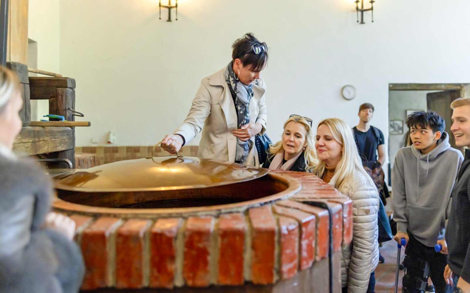 Visitors observing brewing process at Dětenice Brewery during Prague medieval dinner show tour.