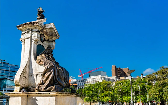 Monument in Manchester city center with modern buildings in the background.