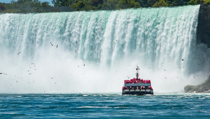 Niagara Falls cruise boat approaching Horseshoe Falls with mist rising, Canada.